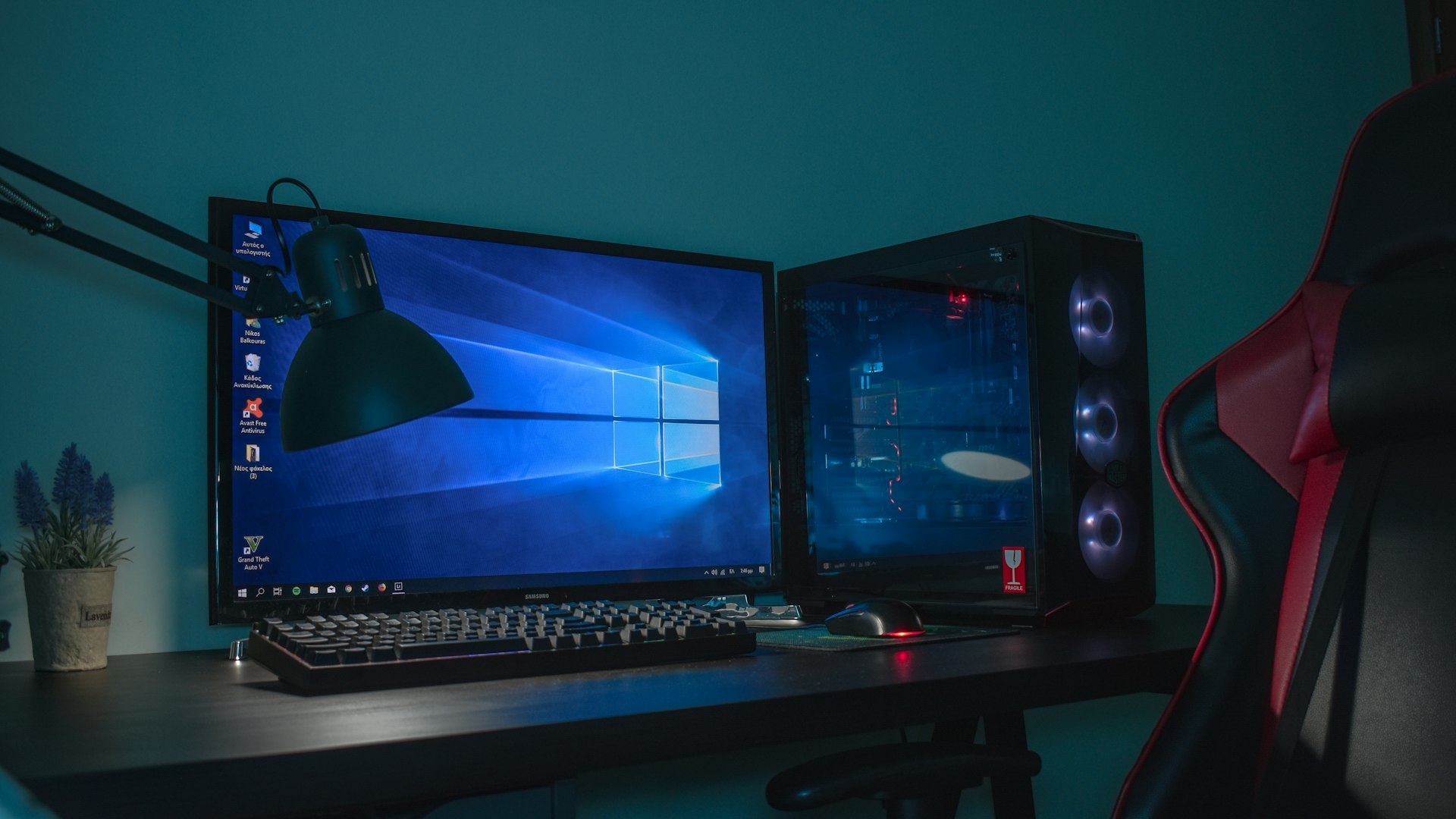 A dimly lit desk with a glowing gaming setup